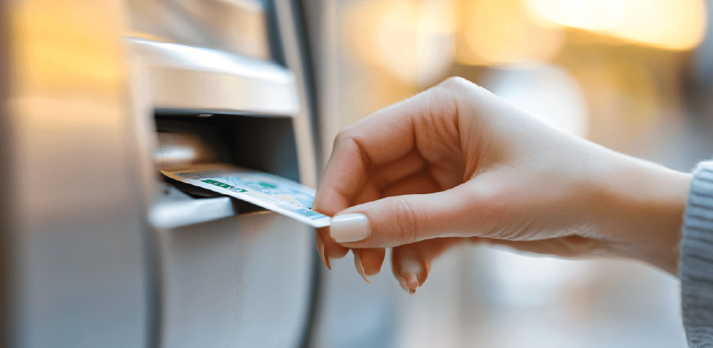 Person inserting credit card into ATM machine.